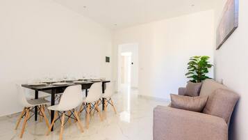 A dining area with a table set for four, surrounded by chairs with wooden legs.