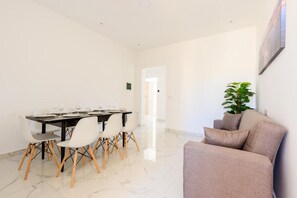 A dining area with a table set for four, surrounded by chairs with wooden legs. - RODOLFU F8 (Tas-Sliema)