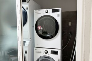 A stacked washer and dryer unit with a 12-year warranty and a 10-year warranty label. - SUWON 3S HOTEL STAR (HOMAESIL) (Suwon)