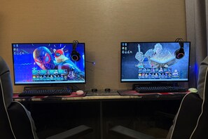 Two computer monitors on a desk with gaming peripherals, suggesting a gaming setup. - SUWON 3S HOTEL STAR (HOMAESIL) (Suwon)