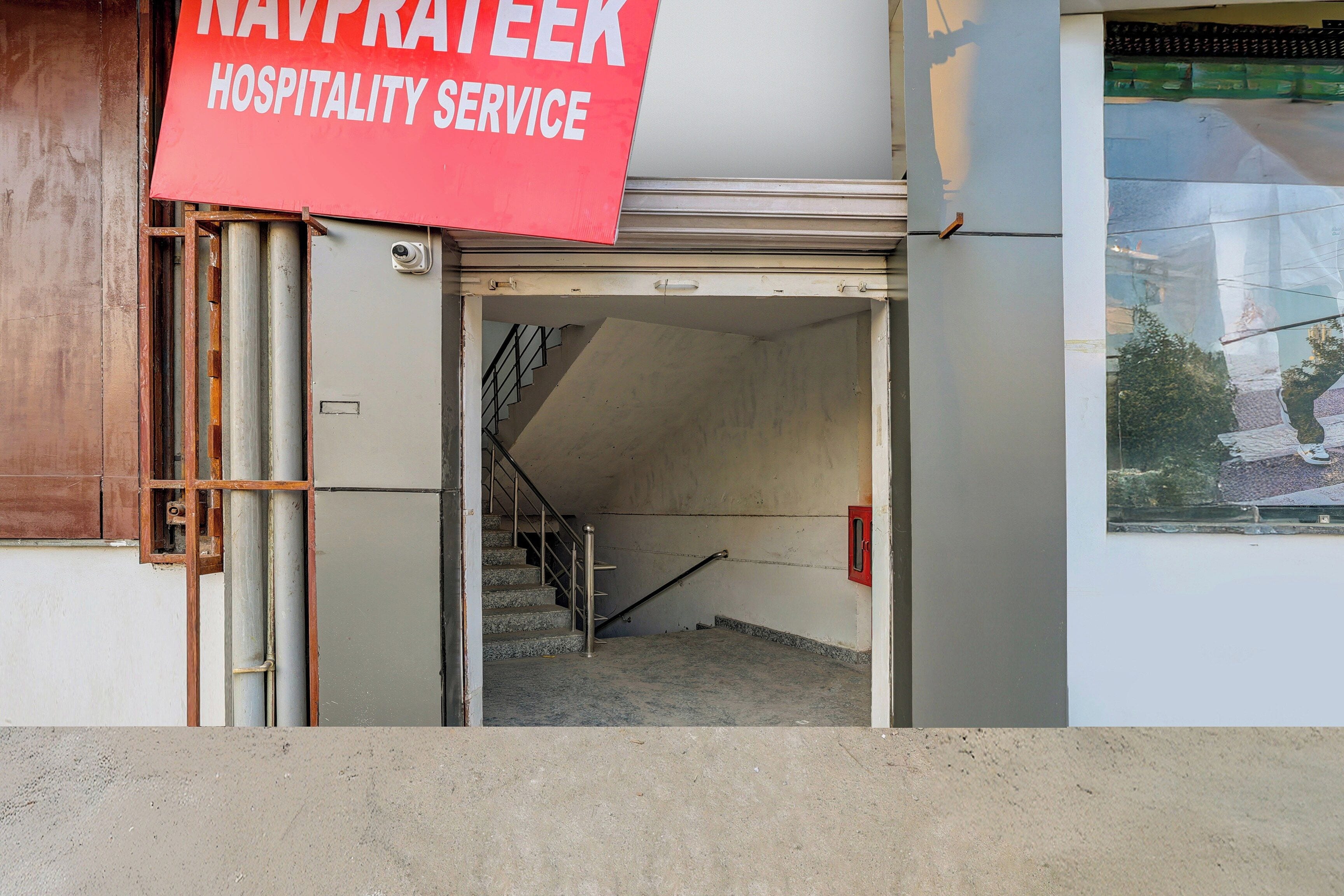 Una puerta cerrada con un cartel que indica 'NAVPRATEEK HOSPITALITY SERVICE' encima.