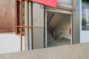 A building entrance with a staircase leading to an upper floor.