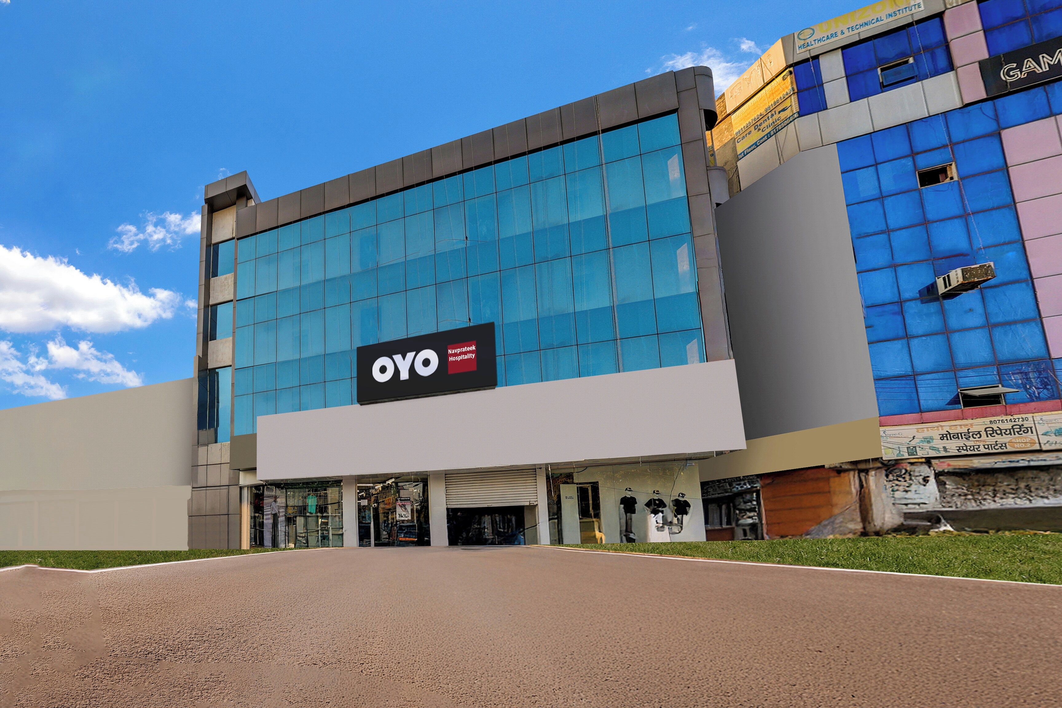 A modern building with a large glass facade, a prominent OYO Hospitality sign, and a visible entrance.
