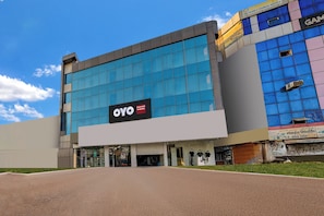 A modern building with a large glass facade, a prominent OYO Hospitality sign, and a visible entrance.