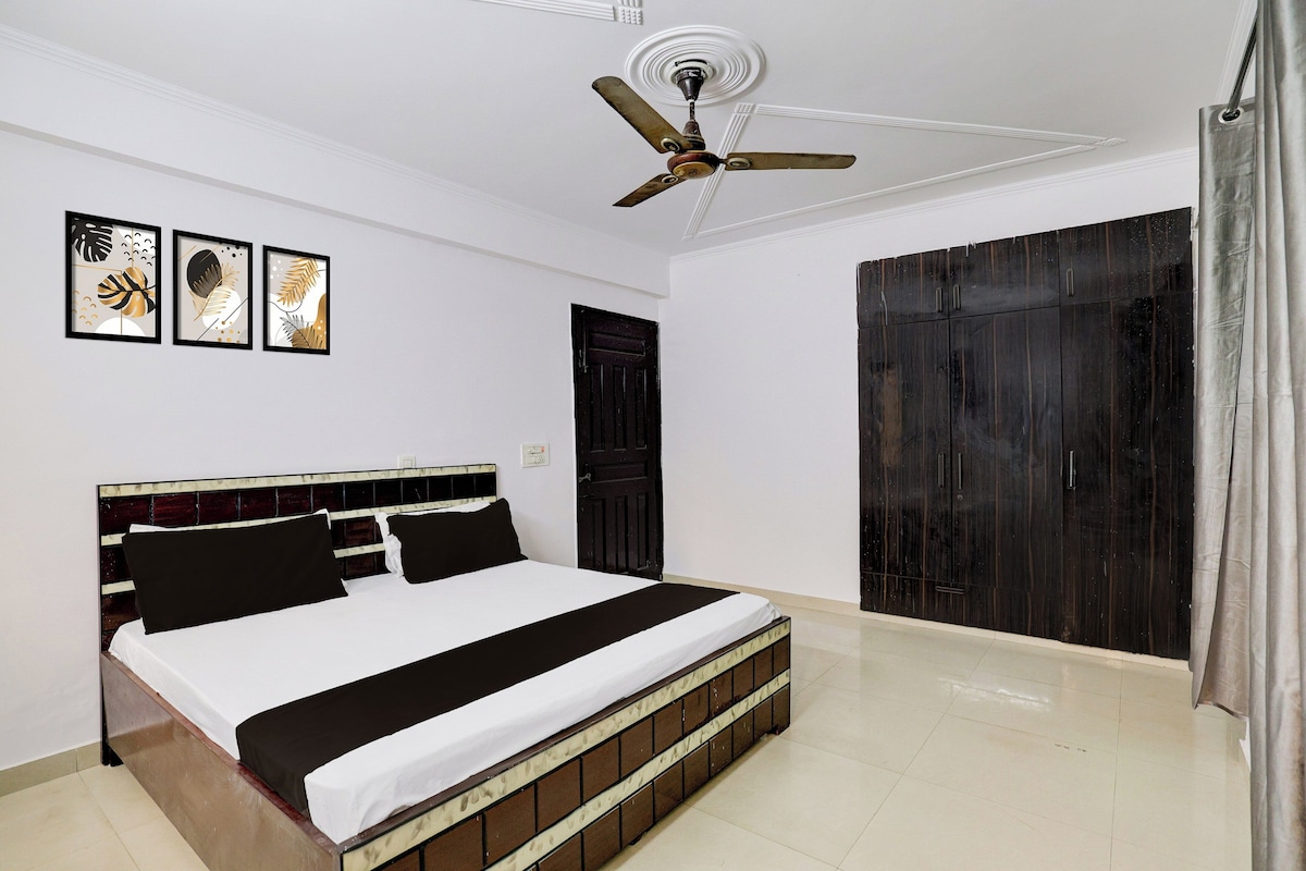 Une chambre à coucher avec un lit, un ventilateur de plafond, une porte et une armoire.