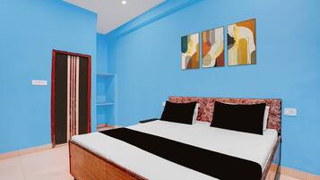 Een slaapkamer met een bed, een kledingkast en drie kunstwerken aan de muur.