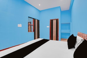 Une pièce comprenant un lit, une armoire et un miroir au mur.