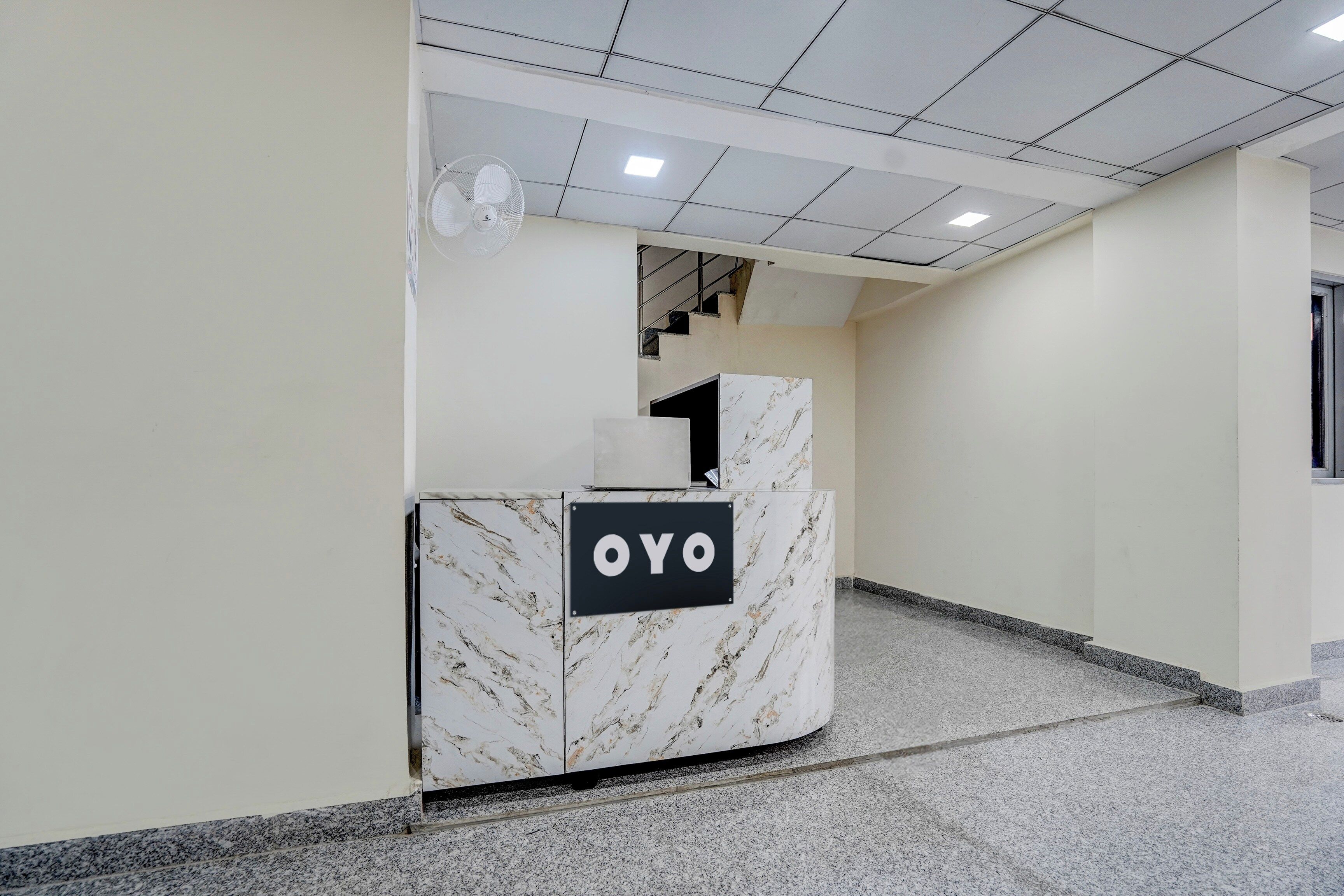 Marmorikuvioitu vastaanottotiski, jossa on kyltti, jossa lukee »OYO».