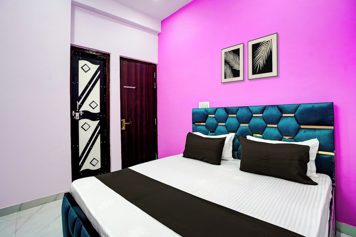 Un dormitorio con una cama, una puerta y dos cuadros en la pared.