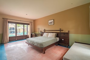 A hotel room with a bed, a desk, a chair, a window with curtains, and a picture on the wall. - Dreamville Beach Homestay (Hoa Hiep)