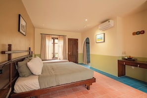 A hotel room with two beds, a desk, and a bathroom visible through a door. - Dreamville Beach Homestay (Hoa Hiep)