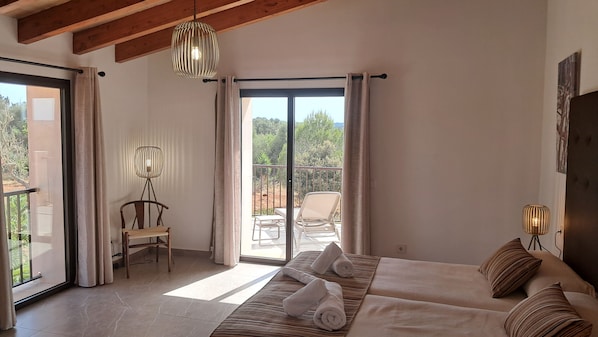 Een slaapkamer met een bed, twee bedlampen, een stoel, een vloerlamp en uitzicht op de omgeving.