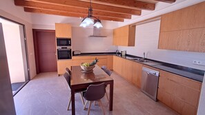 Una cocina moderna con armarios de madera, horno empotrado, microondas y lavavajillas.