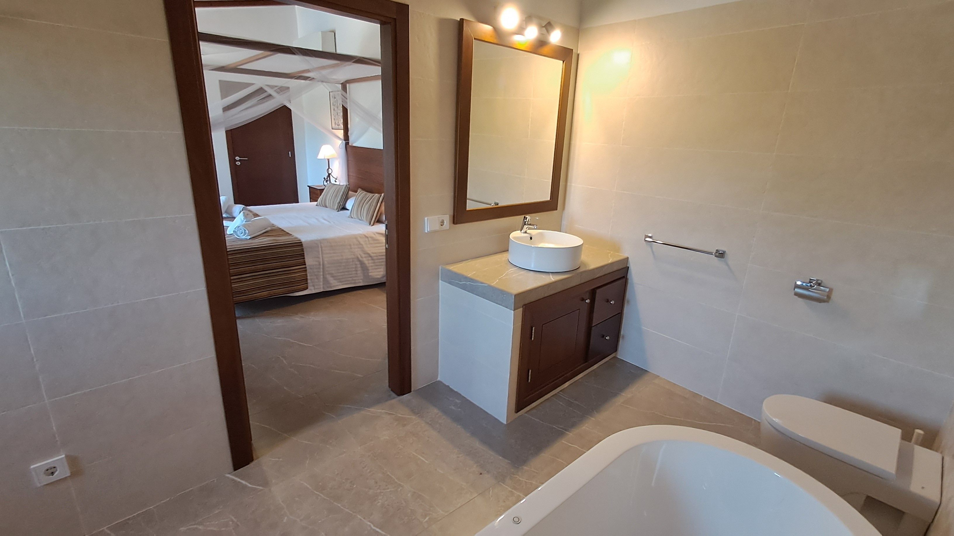 Un baño moderno con bañera, lavamanos y espejo.