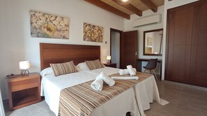 Une chambre d’hôtel avec un grand lit, un bureau et une armoire.