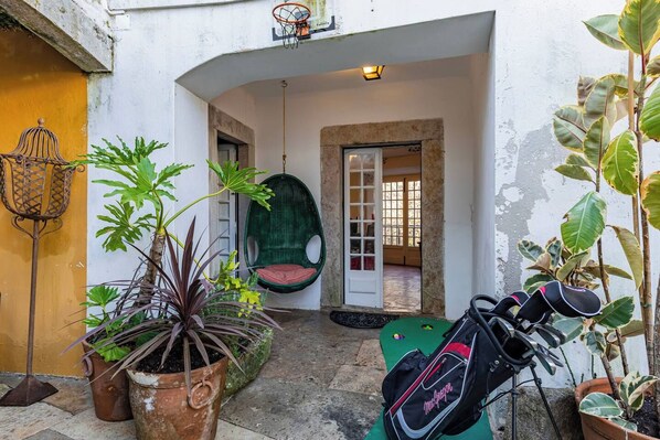 Un cortile con piante in vaso, una poltrona amaca e un portabici.