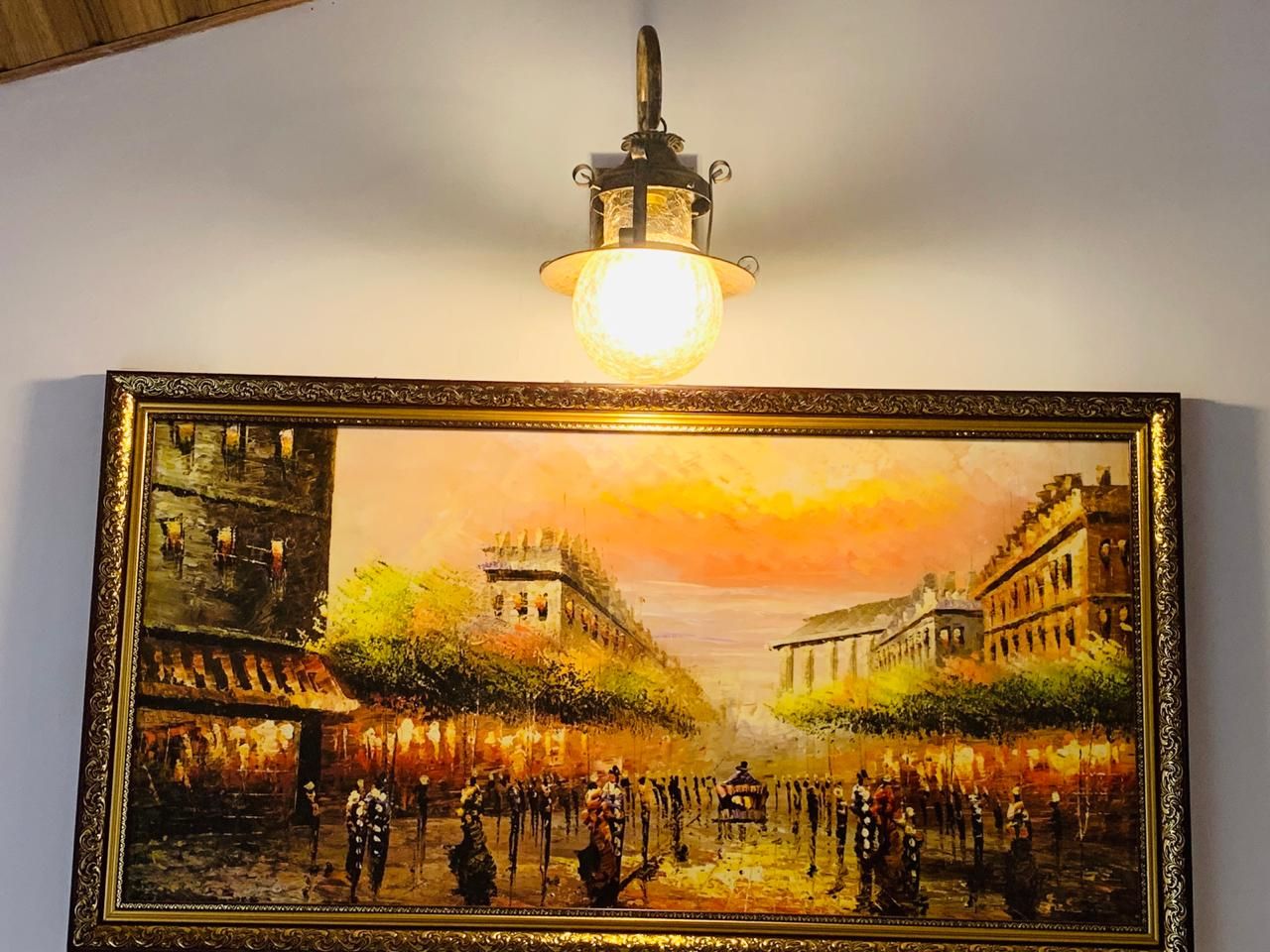 Un tableau encadré représentant une scène de rue historique, avec des bâtiments et des personnes, accroché à un mur.