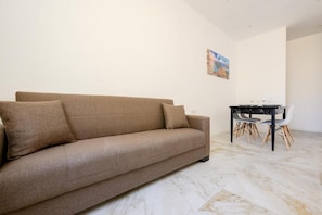 A living room with a sofa and a dining table with chairs. - RODOLFU F5B (Tas-Sliema)