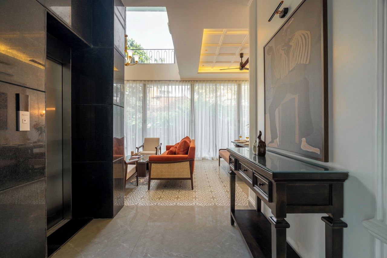 A modern interior with a seating area, a glass table, and a large framed artwork on the wall.
