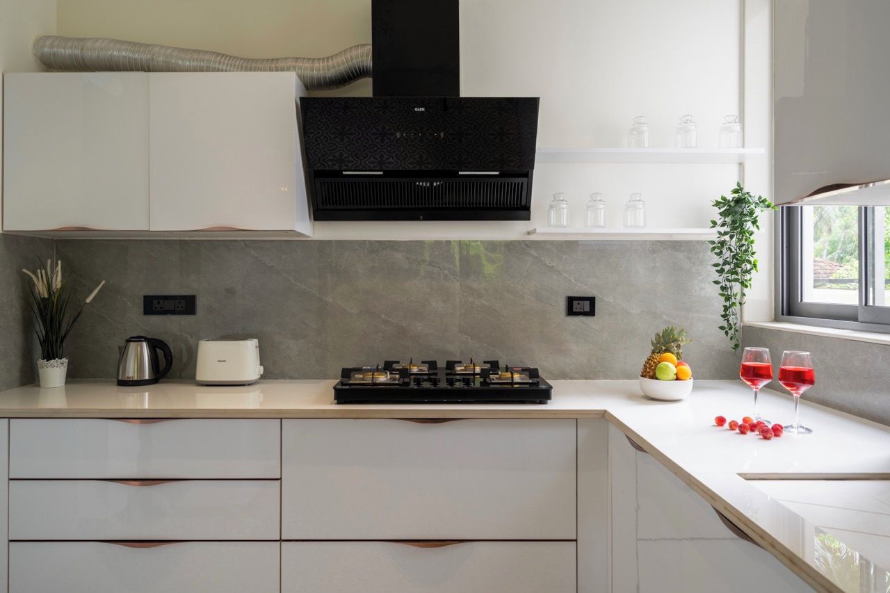 Una cucina moderna con piano cottura integrato, macchina da caffè e una ciotola di frutta.