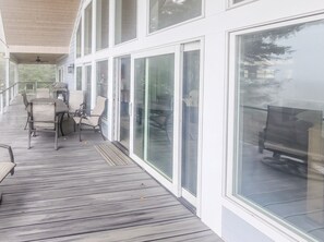 A covered outdoor area with a table and chairs, large windows, and a ceiling fan. - 5-Bedroom, 4-Bathroom A-Frame Mountain House (Roaring Gap)
