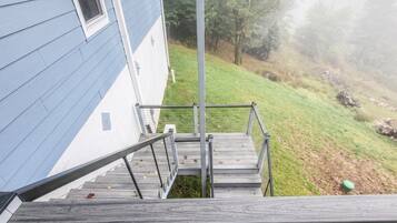 Una escalera de madera que lleva a una casa con fachada azul.