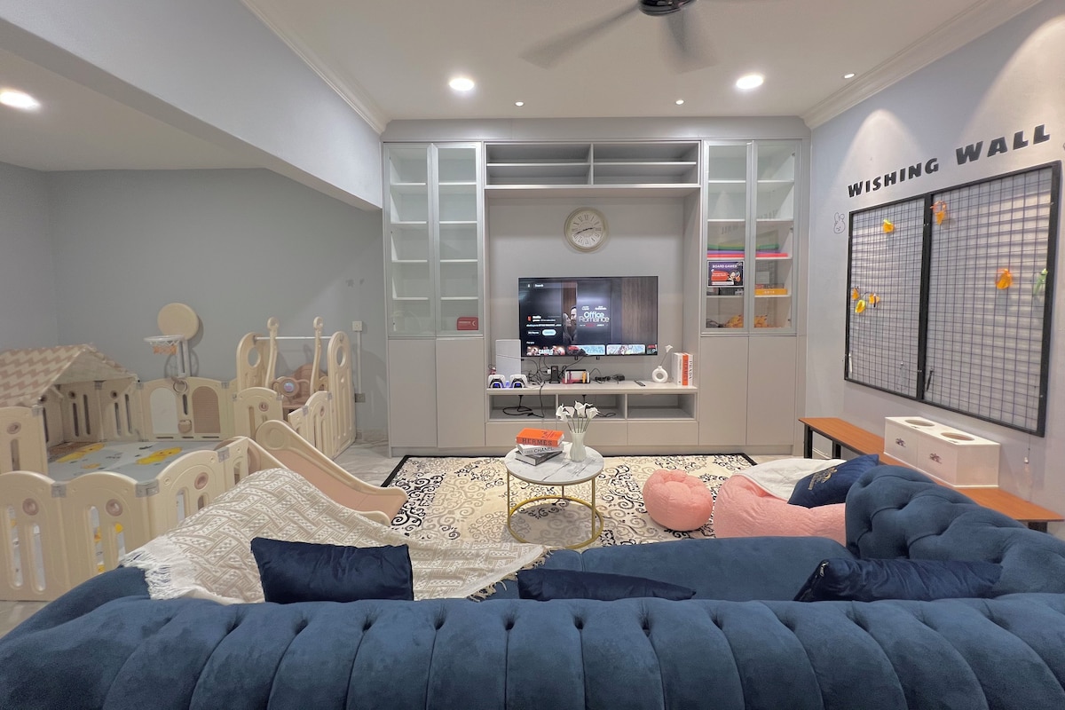 A bedroom with a bed, a television, a ceiling fan, and a wall with a grid pattern.