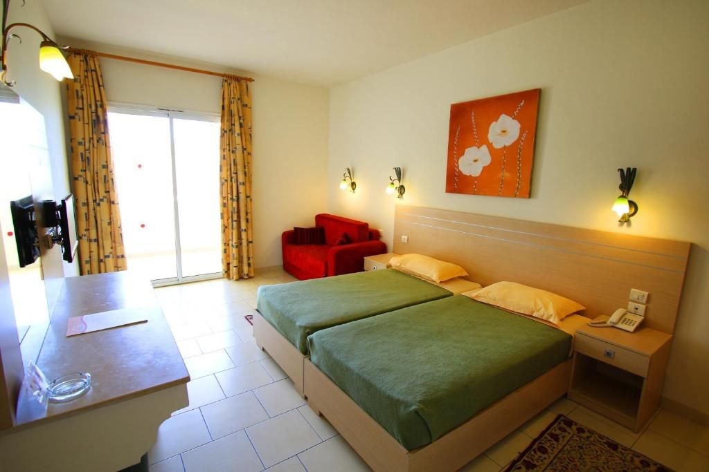 A hotel room with a bed, bedside tables, a desk, and a chair.