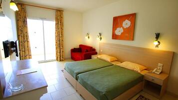 A hotel room with a bed, bedside tables, a desk, and a chair.