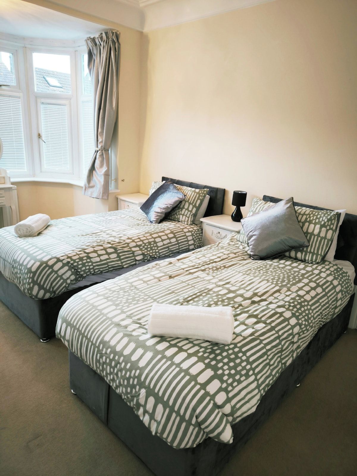 This bedroom has two single beds that can be converted into one double upon request. It features heating and a window with darkening shades, providing a cosy and flexible sleeping space.
