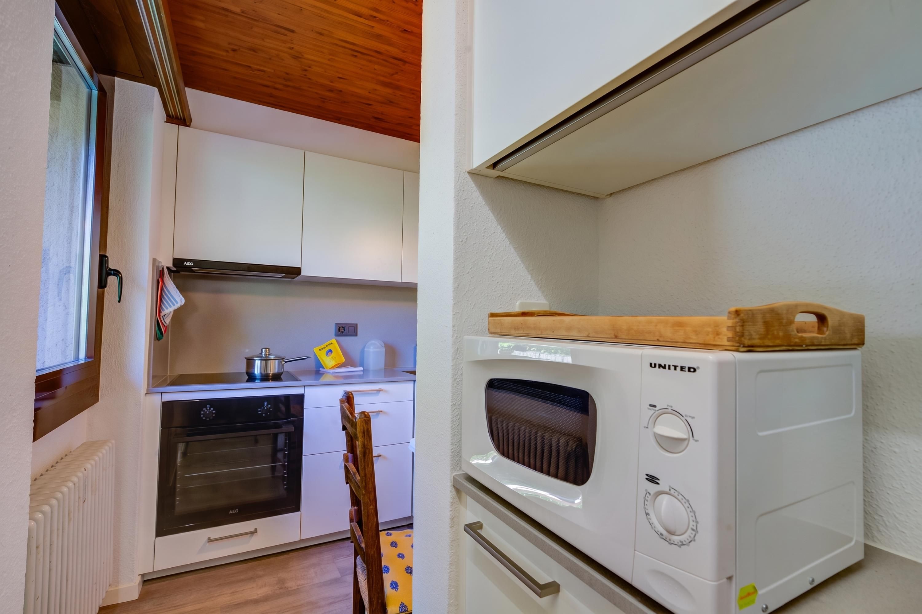 A compact kitchen with a built-in oven, a microwave, and a stove.