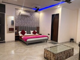 A modern bedroom with a bed, bedside tables, a mirror, and an air conditioning unit.