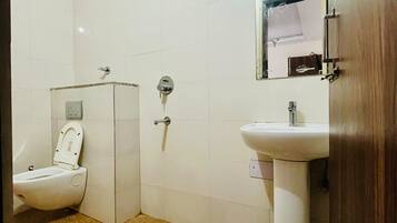 Un baño con inodoro, lavabo y ducha.
