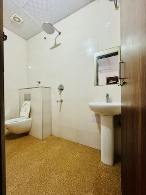 Un baño con inodoro, lavabo y ducha.