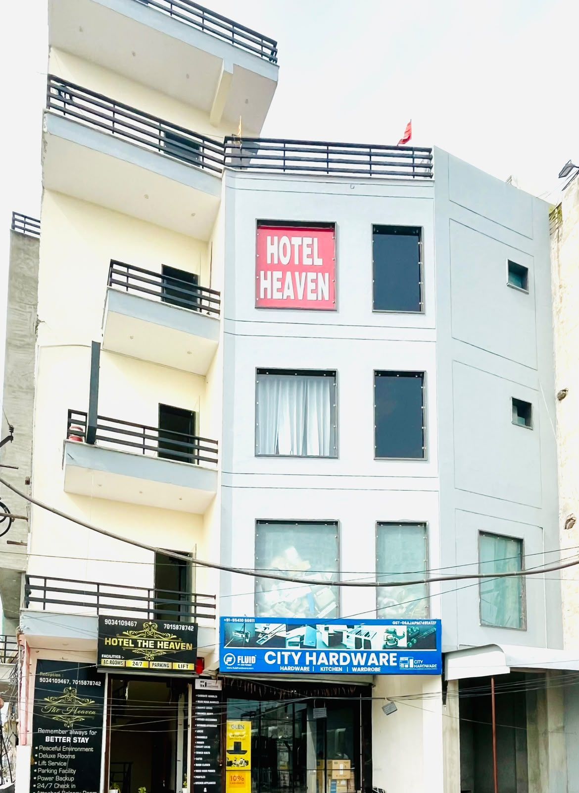 A multi-story hotel named 'Hotel Heaven' with balconies, a signboard, and a storefront for 'City Hardware' below.