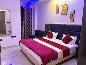 Una habitación de hotel con una cama grande, una mesita de noche, un espejo y cuadros en la pared.