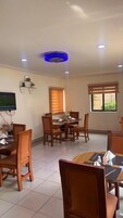 Un comedor con una mesa redonda, sillas y un televisor instalado en la pared.