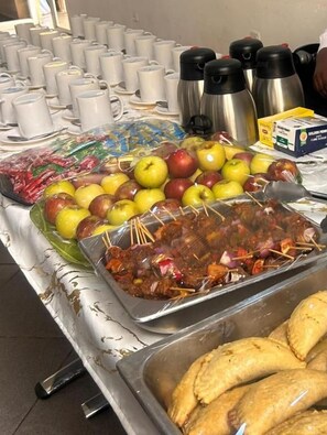 A buffet table with various food items including fruits, skewered meats, and pastries. - Nbte hotels (Kaduna/kaduna state)