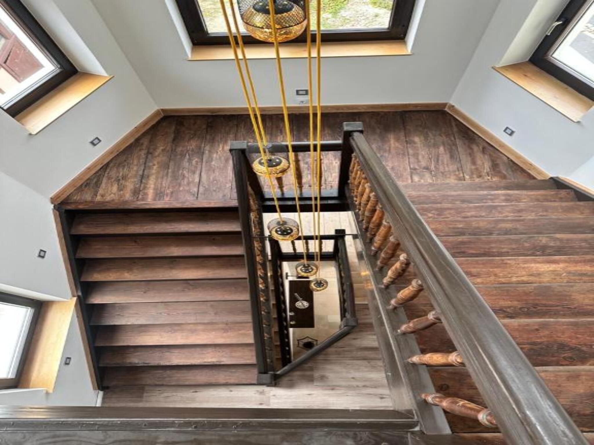 Eine Holztreppe mit Metallgeländer und einer modernen Leuchte.