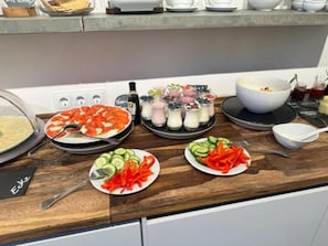 A buffet setup with various dishes including a pizza, salads, and a bowl of soup. - Hotel Villa WUN (Wunsiedel)