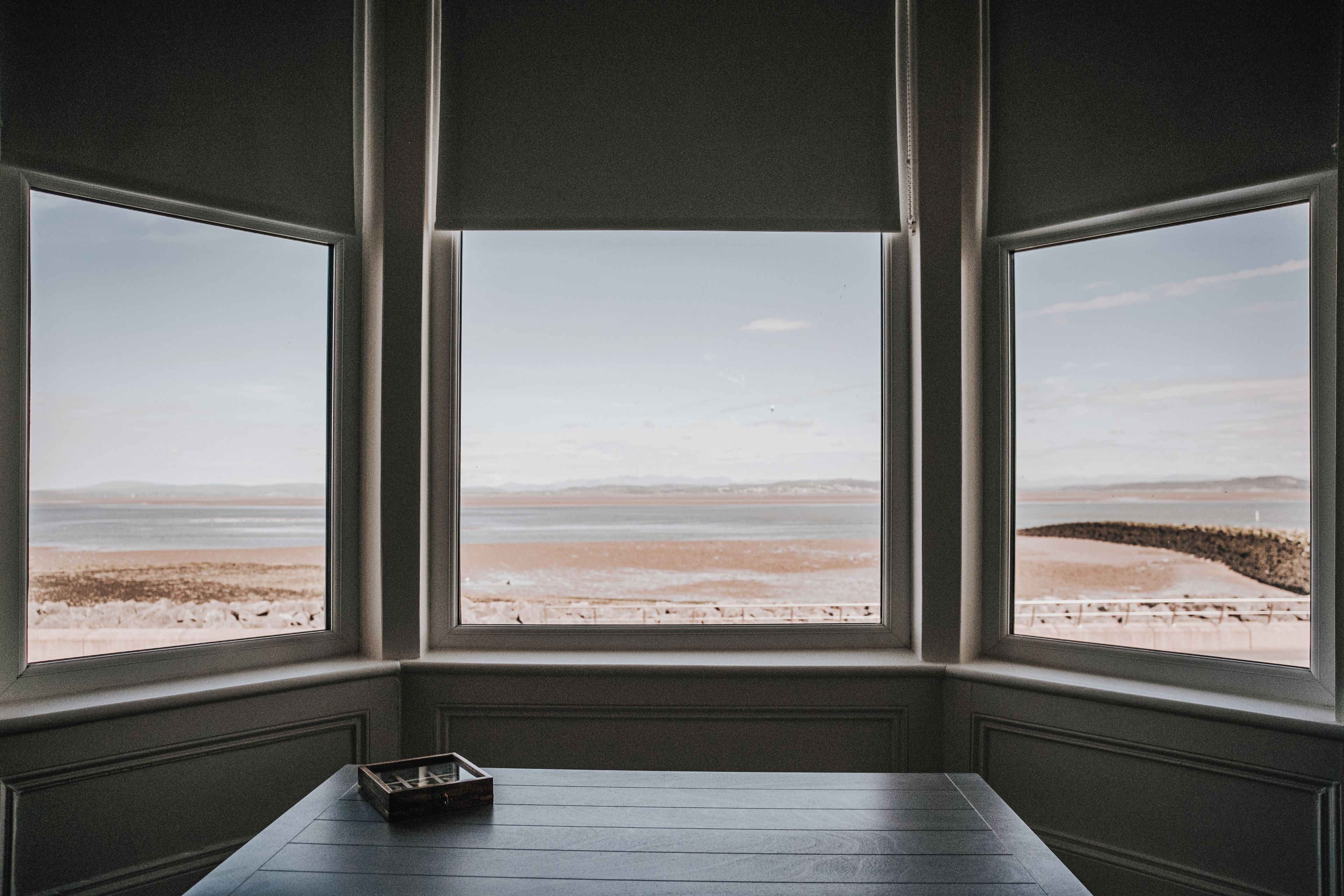 A room with a large window overlooking a beach.