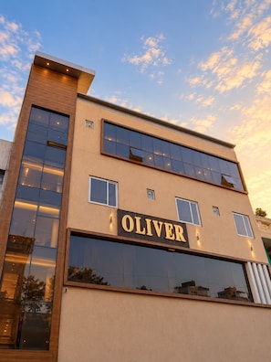 A modern building with a prominent 'OLIVER' sign on the facade.