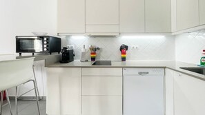 Una cocina moderna con microondas, cafetera y lavavajillas.