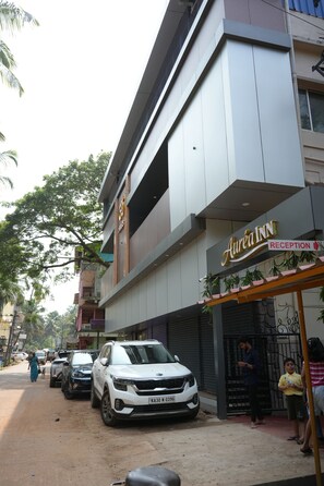 Un edificio con un letrero que dice 'Aurain Inn Reception' y un coche blanco estacionado al frente.