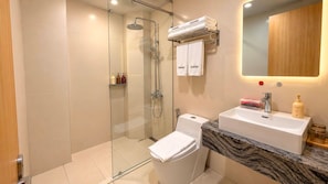 A modern bathroom with a glass-enclosed shower, a white toilet, and a marble countertop sink. - SHANKEE Hotel Nguyen Thai Hoc (Ben Thanh)