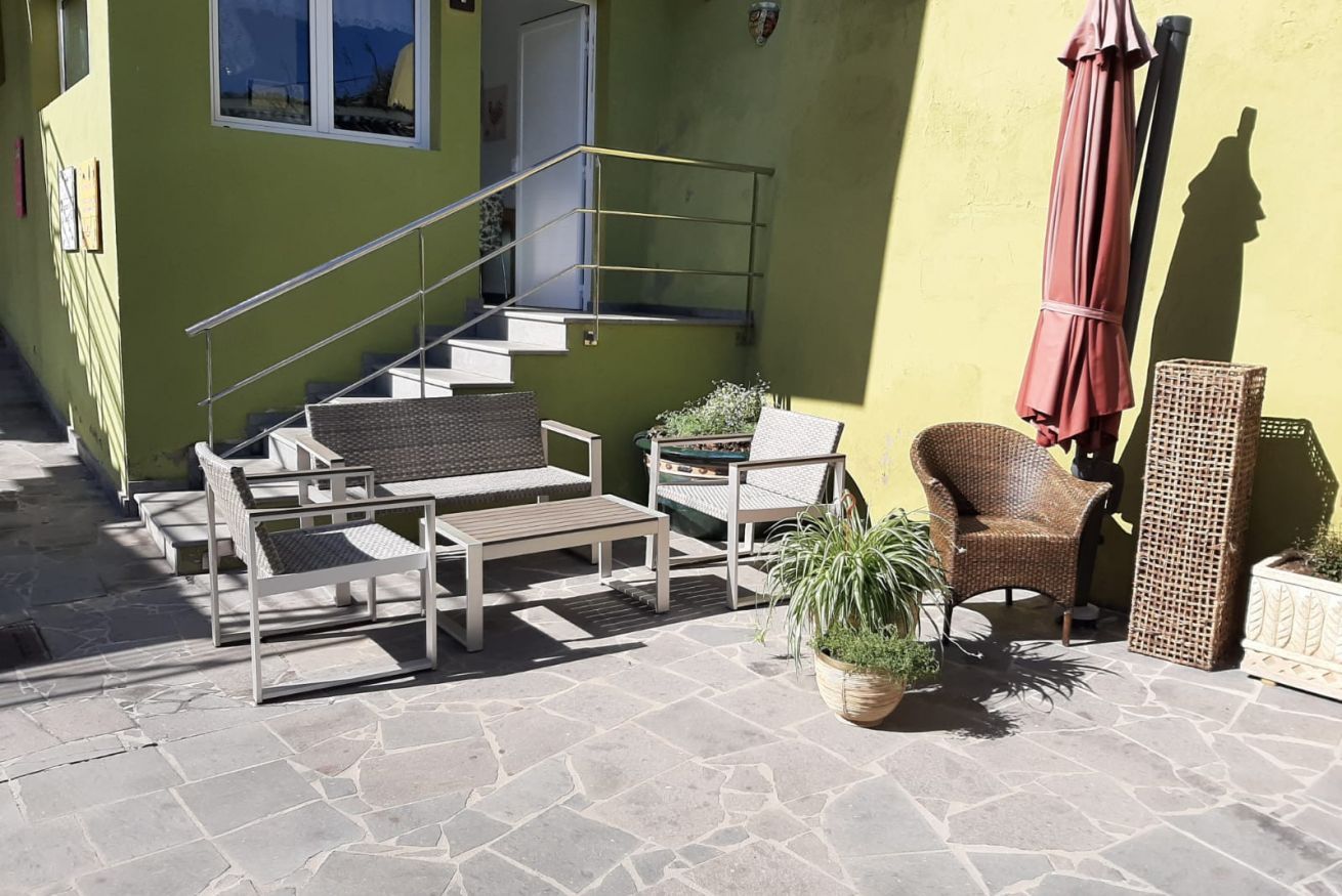 Een terras met tuinmeubilair, een trap en een potplant.