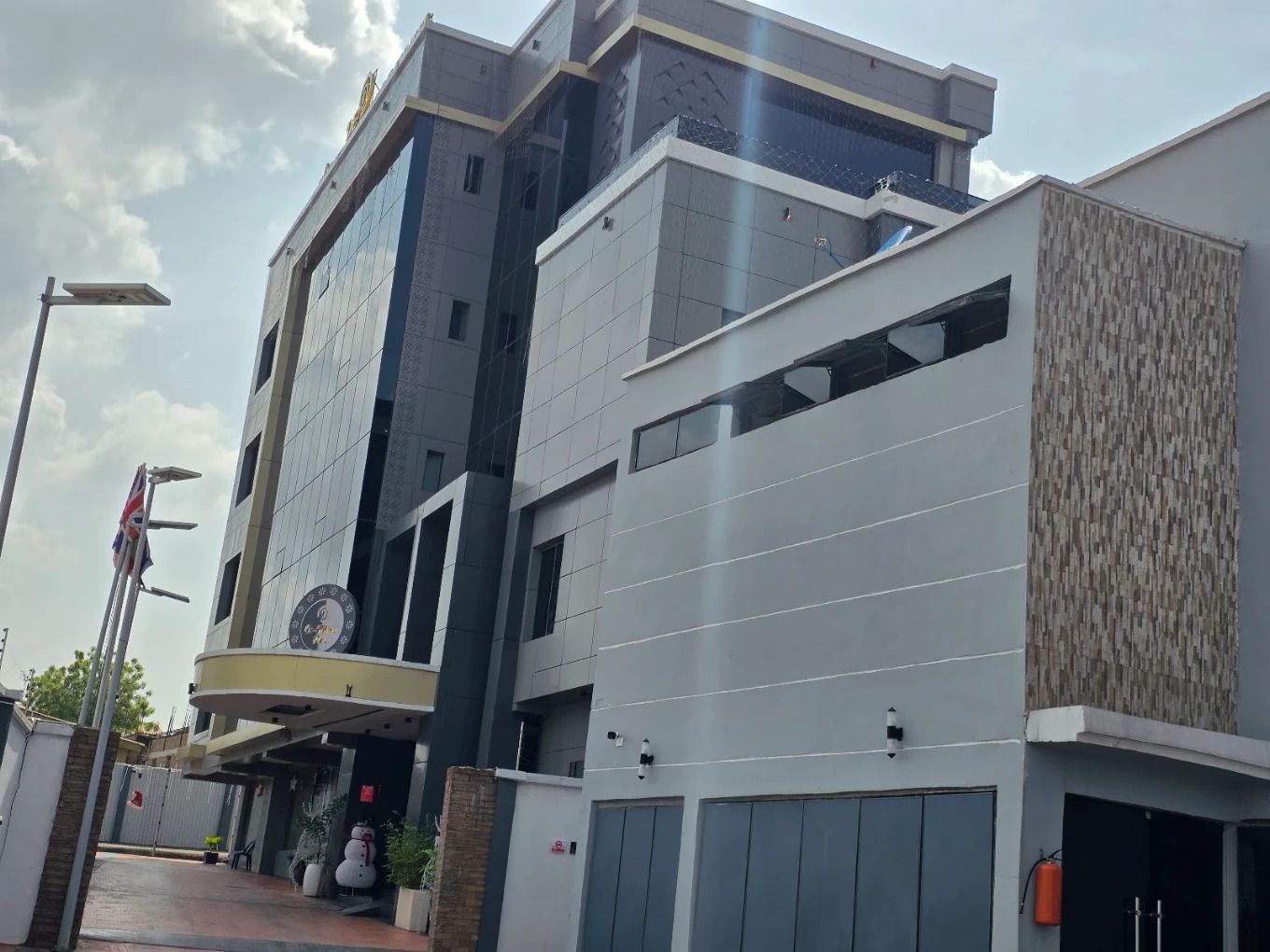 A modern multi-story building with a flat roof, large windows, and a visible clock on the facade.
