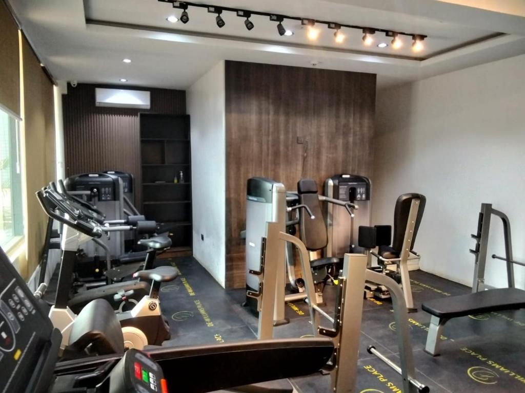 Un gimnasio con equipo de ejercicio, una cinta de correr y un aire acondicionado instalado en la pared.