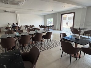A conference room with tables and chairs, a patterned floor, and a large window.