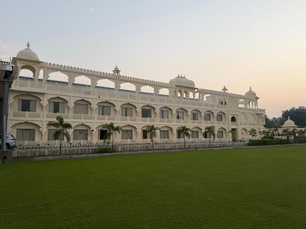 A large, multi-story building with a symmetrical facade, arched windows, and a central dome.